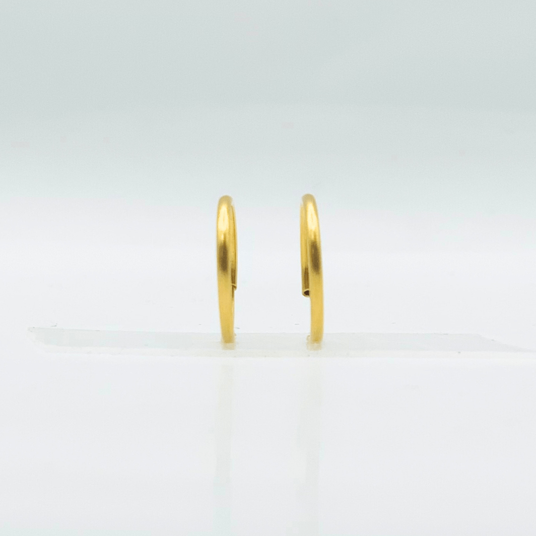 Gold hoop earrings on a light gray background
