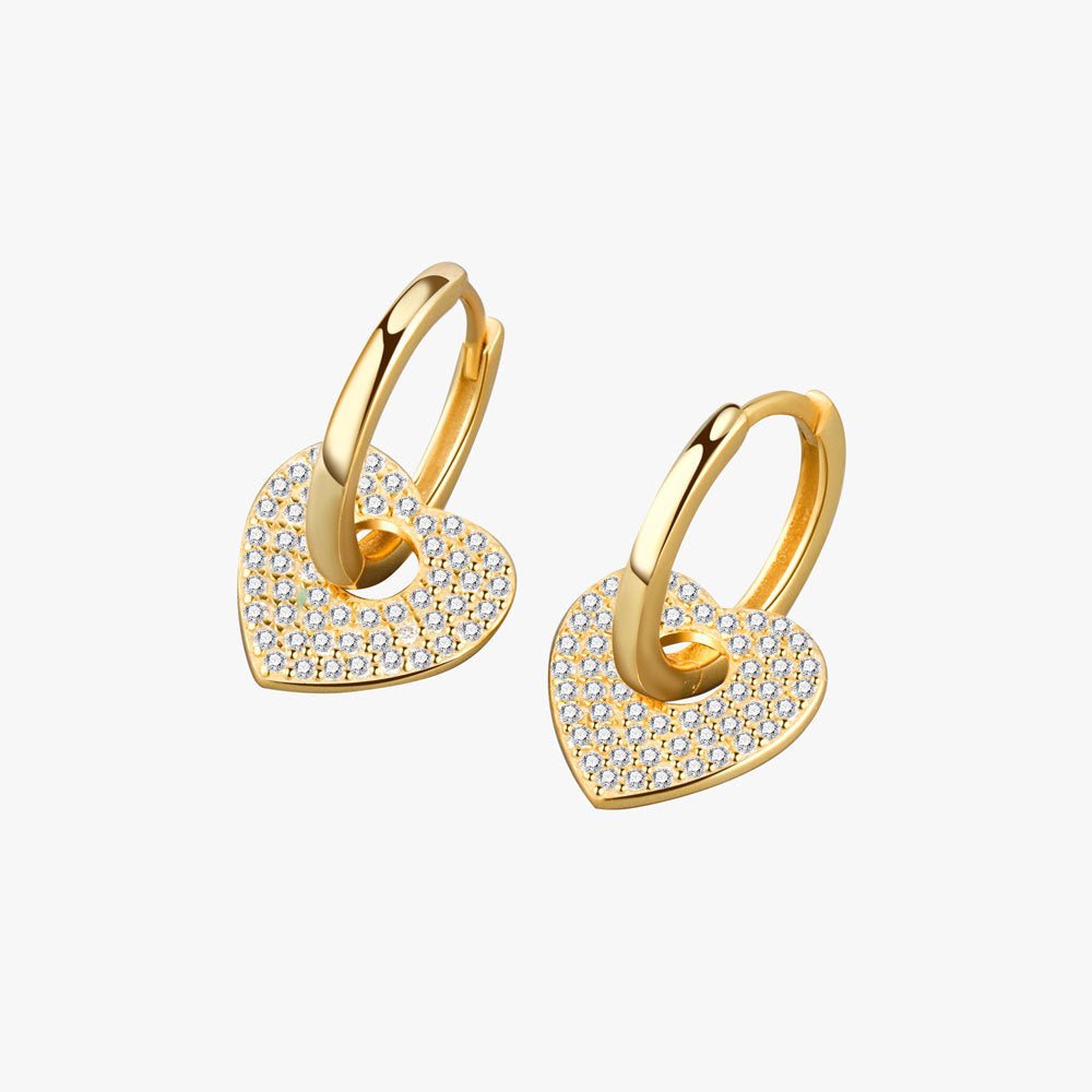 Gold heart-shaped earrings with embedded stones on a white background