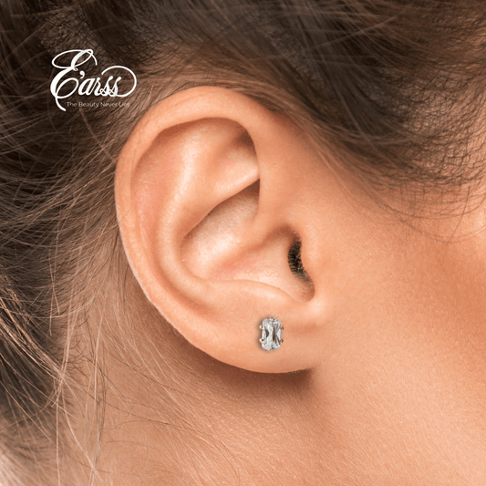 Close-up of an ear wearing a silver earring with 'Ears' brand logo.