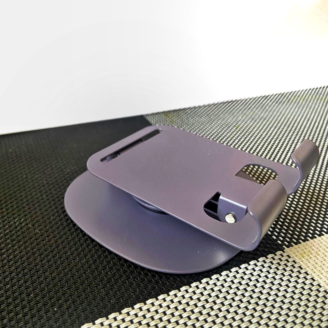 Purple phone stand on a textured surface