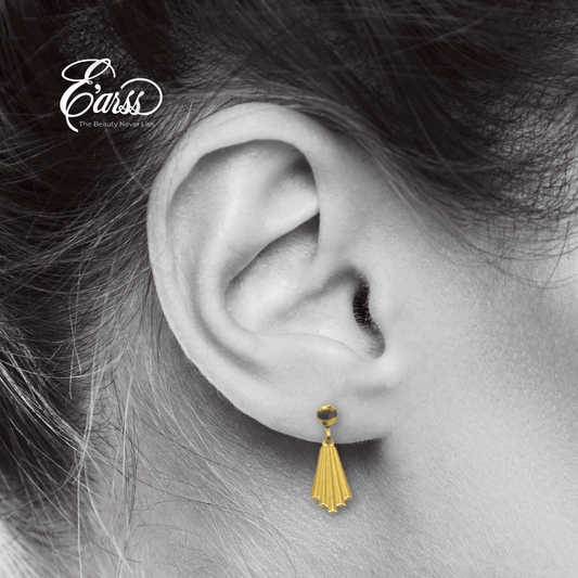 Gold earring worn by a person with 'Eauss' branding.