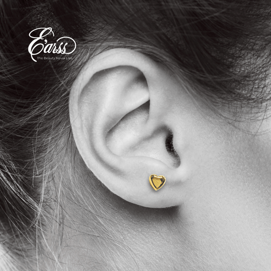 Gold heart-shaped earring worn on an ear with 'Eauss' branding.