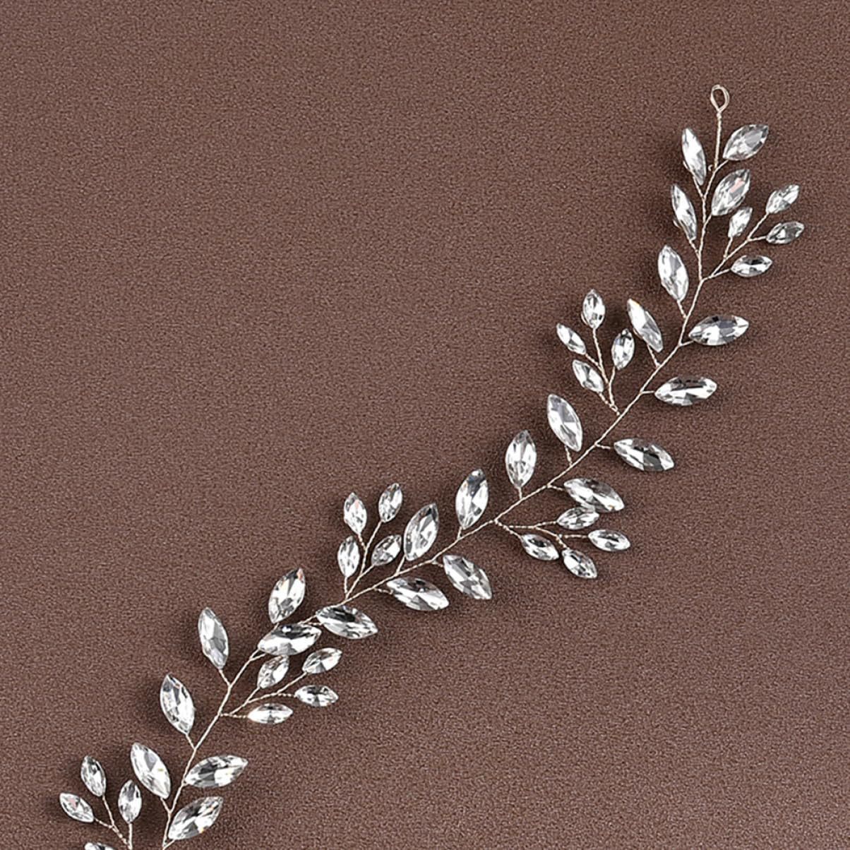 Silver leaf-shaped jewelry piece on a brown background