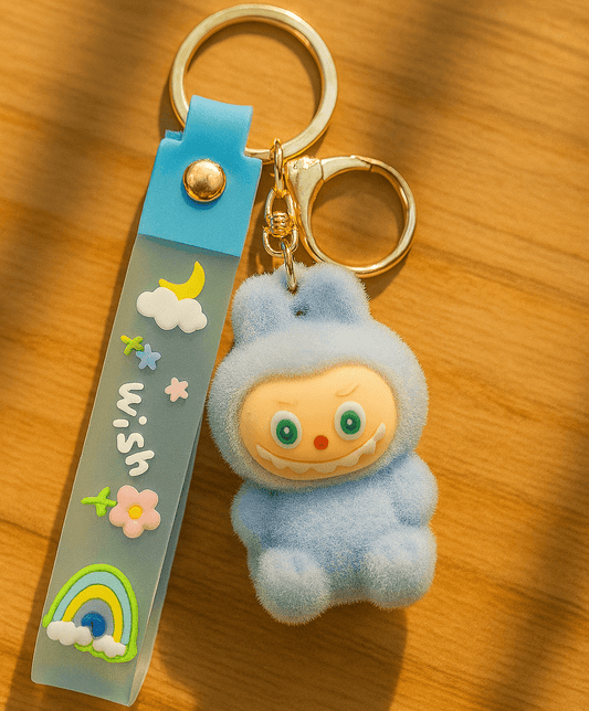 Keychain with plush toy labubu character and decorative strap on a wooden surface
