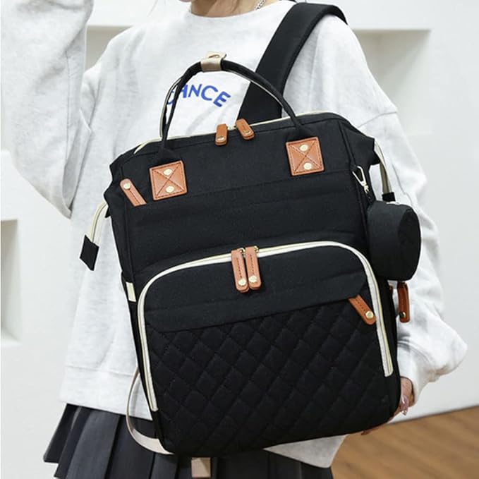 Black quilted backpack with brown accents worn by a person on a light background