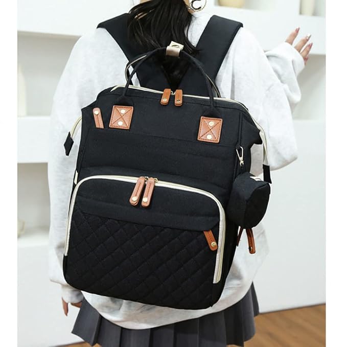 Black backpack with brown accents worn by a person indoors