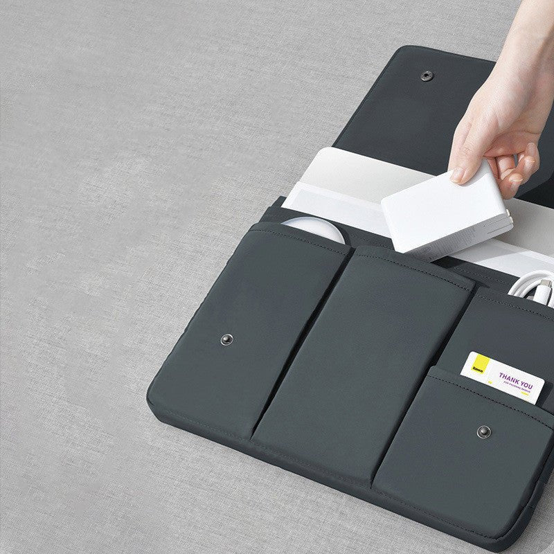 Black laptop sleeve with compartments on a gray surface