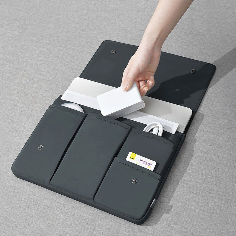 Black laptop sleeve with compartments on a gray surface