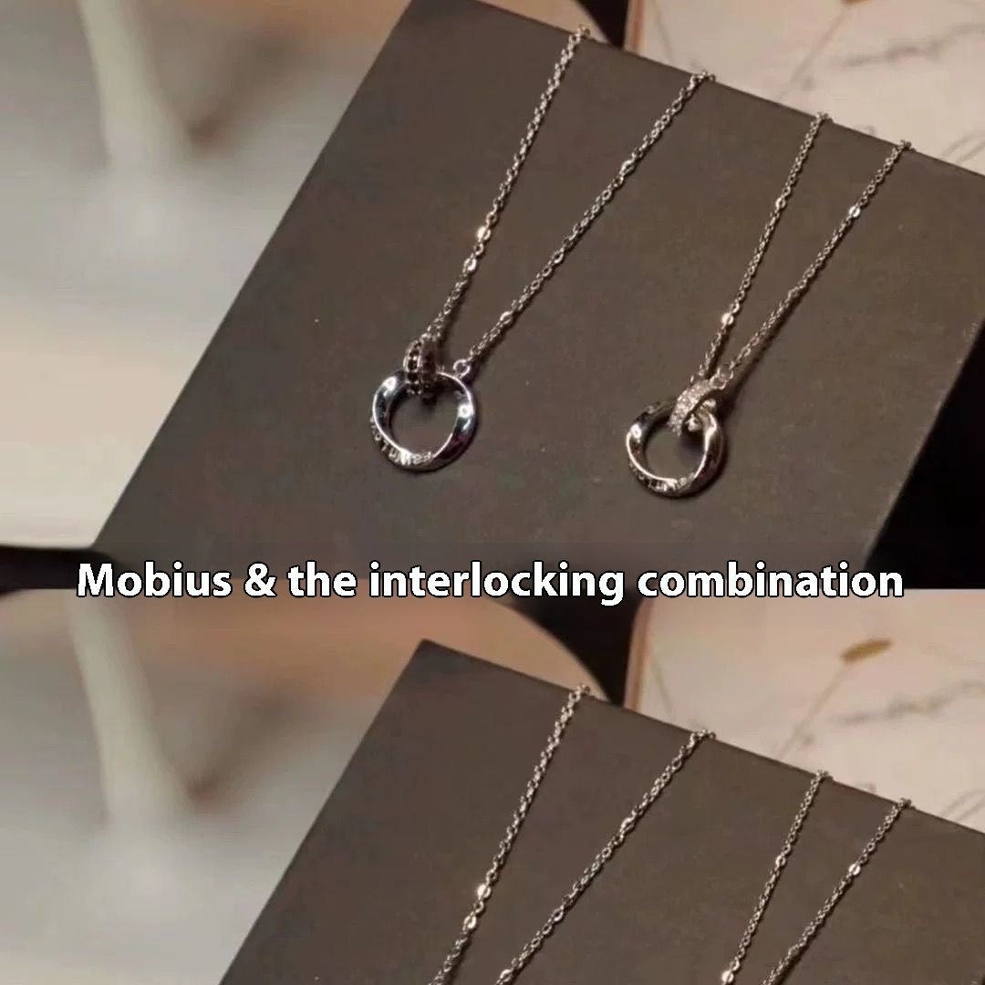 Two silver necklaces with interlocking pendants on a dark surface.