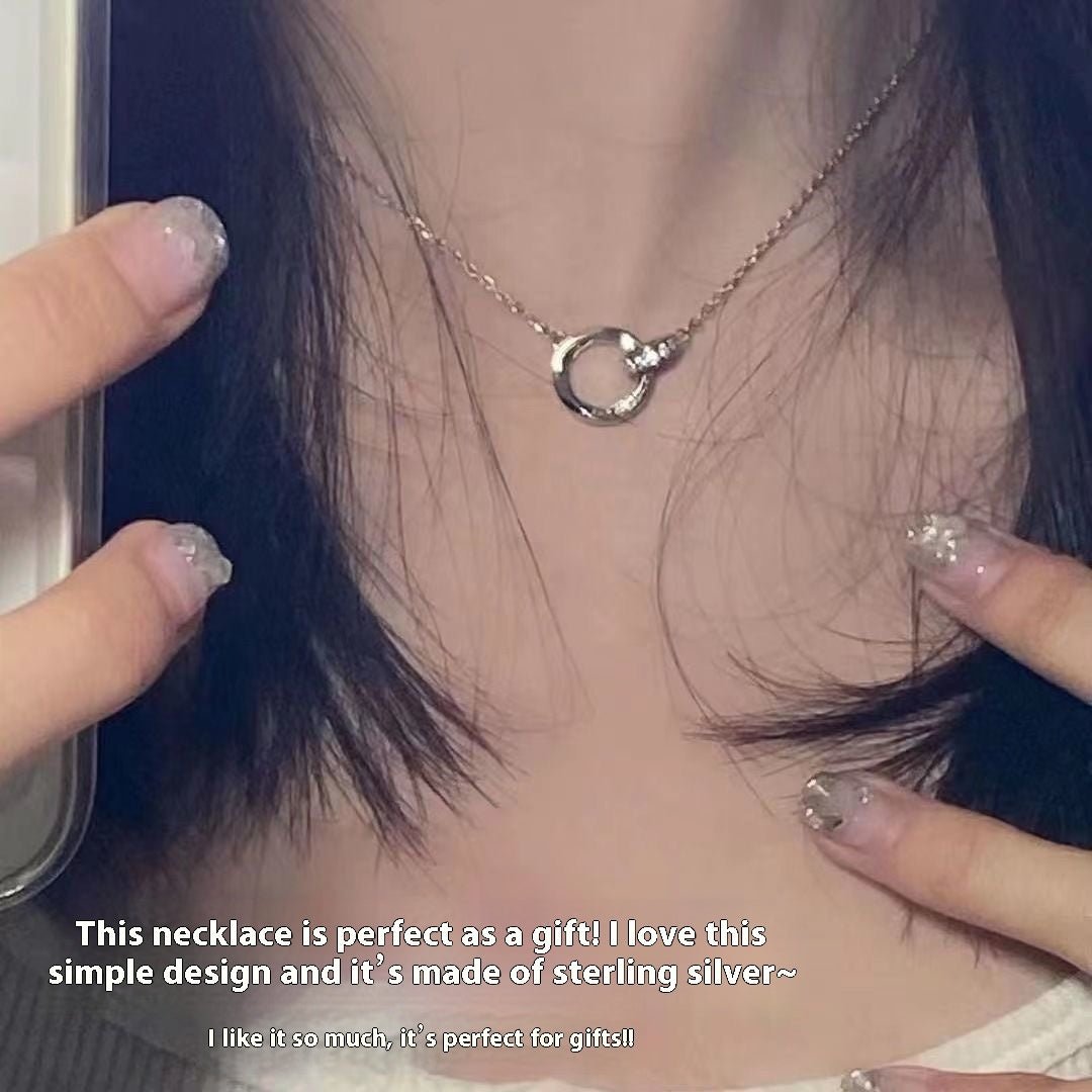 Silver necklace being worn and held by a person with text describing the necklace.