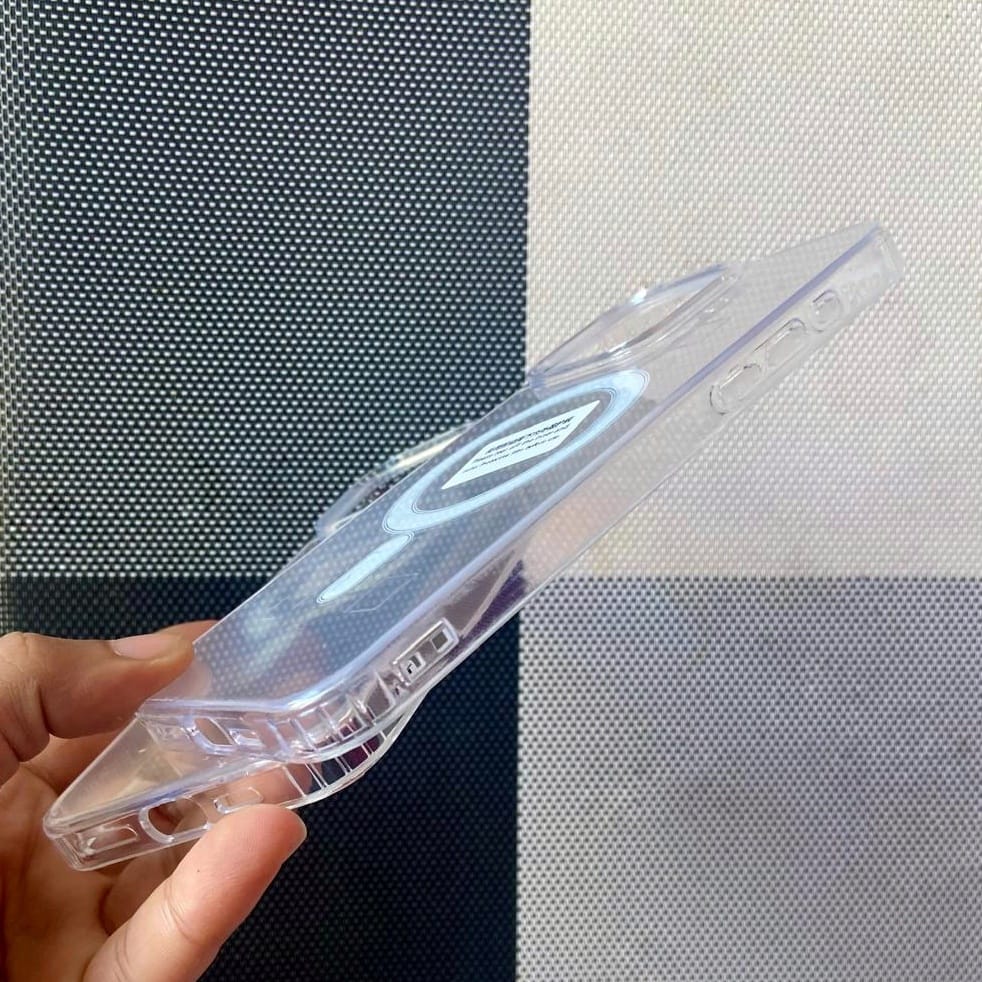 Clear plastic object held by a hand against a checkered background