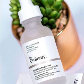 The Ordinary skincare serum bottle with a plant in the background