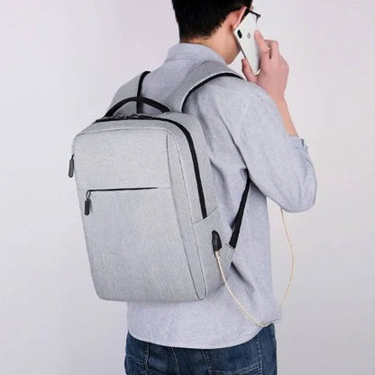 Person wearing a gray backpack and using a smartphone on a plain background
