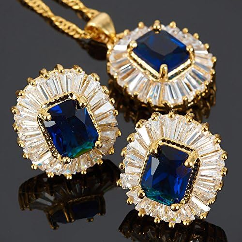 Gold earrings with blue gemstones on a reflective surface