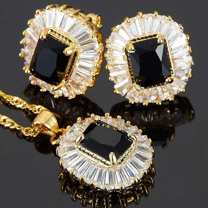 Jewelry set with black gemstones and gold accents on a reflective surface