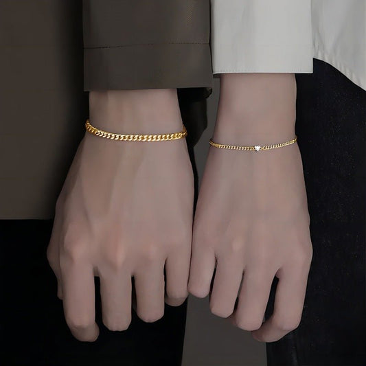 Gold anklets on a person's ankles against a neutral background