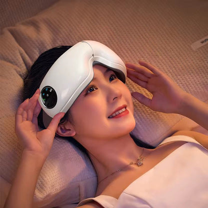 Woman using a white eye massager on a beige blanket