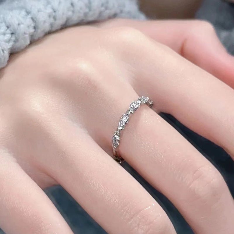 Silver ring with small diamonds on a person's finger