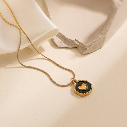 Gold necklace with a heart pendant on a beige fabric background