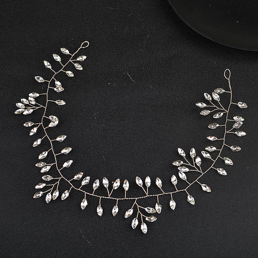 Silver necklace with leaf-like design on a black background