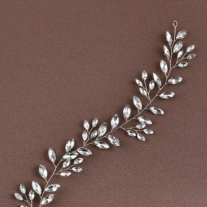 Silver leaf-shaped jewelry piece on a brown background
