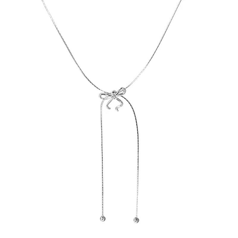 Silver necklace with a bow pendant on a white background