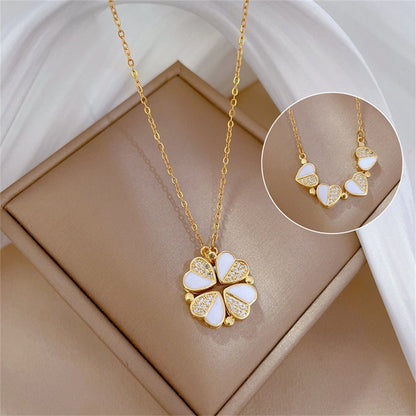 Gold necklace with a white floral pendant on a beige box