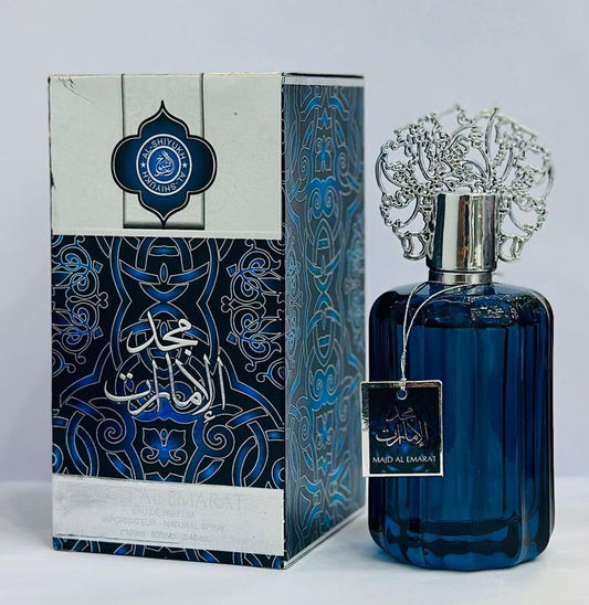 Blue perfume bottle with intricate design and decorative box on a light gray background