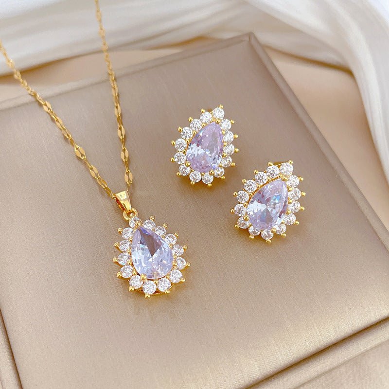 Jewelry set with gold necklace and earrings on a beige fabric background