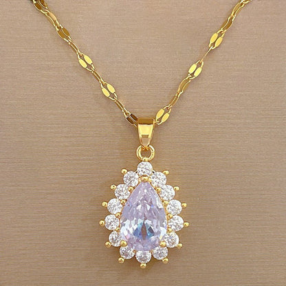 Gold necklace with a pendant featuring a purple teardrop-shaped gemstone on a beige background