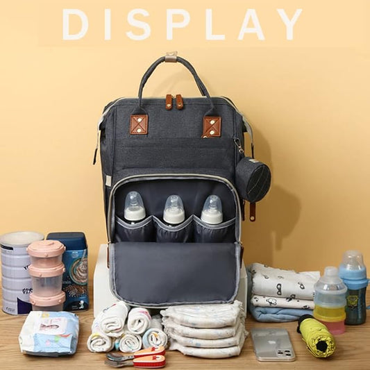 Diaper bag with baby items on a wooden surface against a beige background