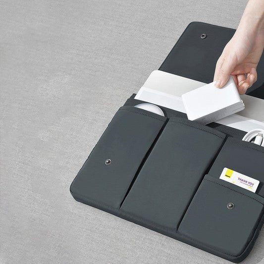 Black laptop sleeve with compartments on a gray surface