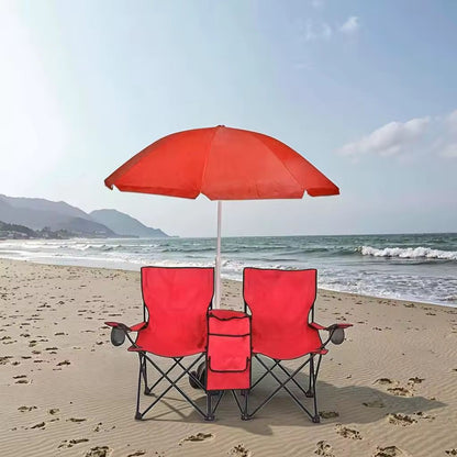 Red beach chairs with an umbrella on a sandy beach with ocean and sky in the background
