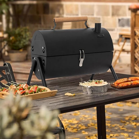 Black portable grill on a wooden table with food and outdoor setting