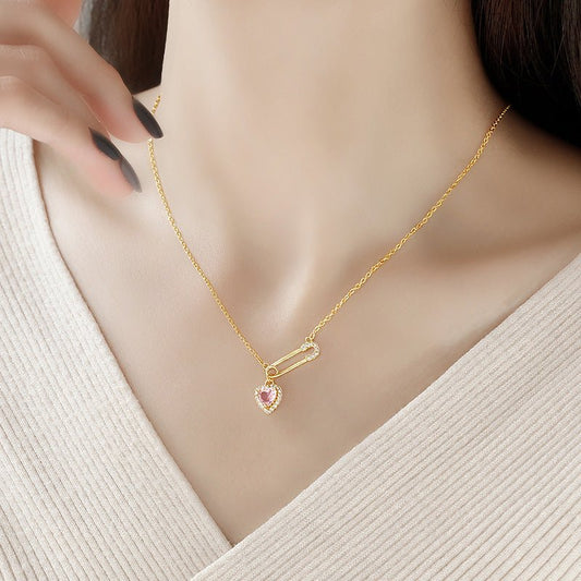 Gold necklace with a pink gemstone on a mannequin