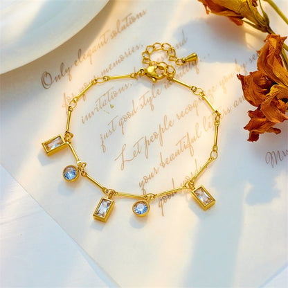 Gold bracelet with gemstones on a decorative card with floral elements