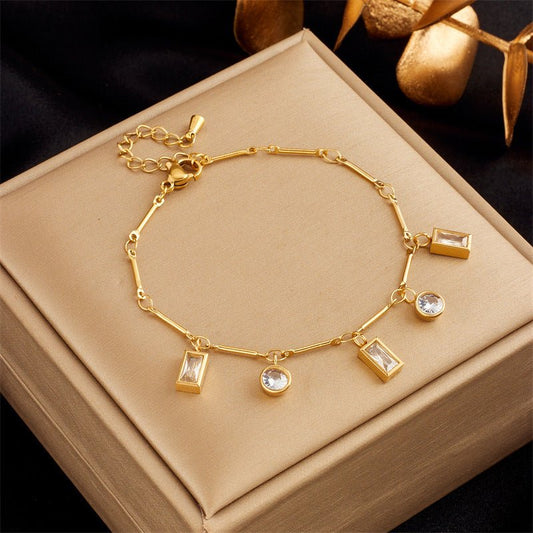 Gold bracelet with charms on a beige jewelry box