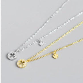 Three necklaces with different pendants on a gray background