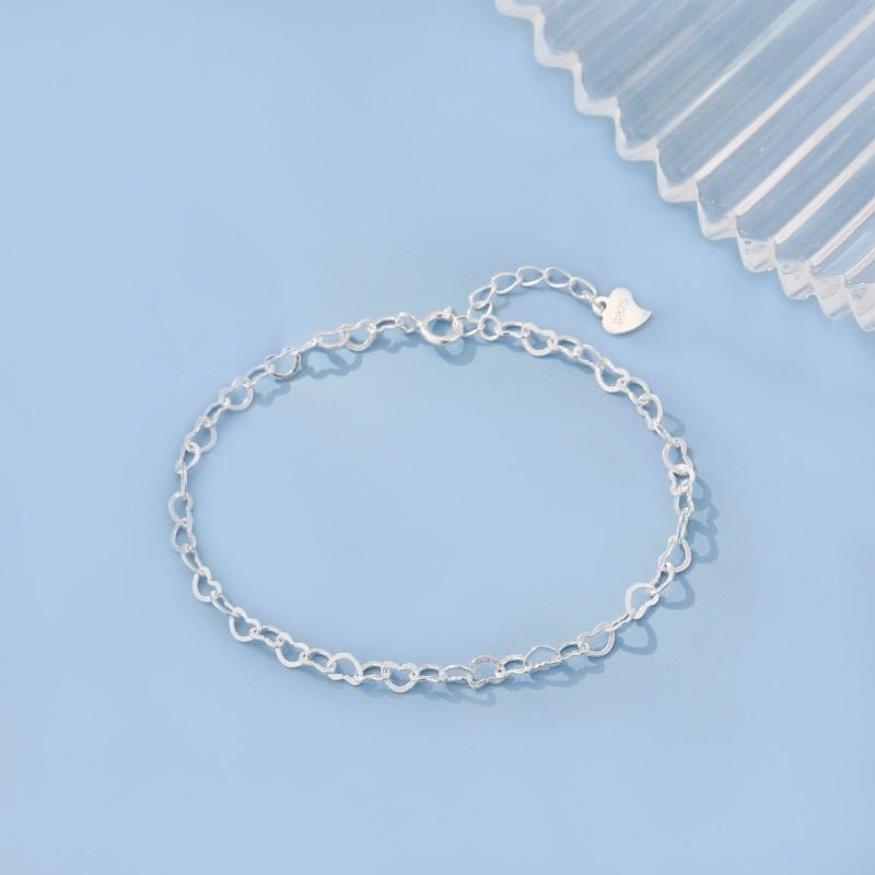 Silver chain bracelet on a light blue background