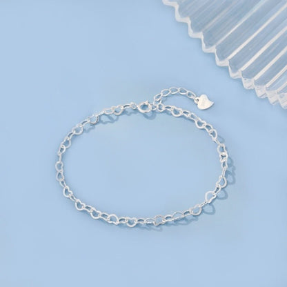 Silver chain bracelet on a light blue background