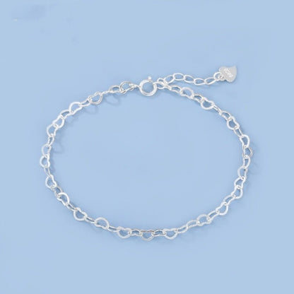 Silver chain bracelet on a light blue background