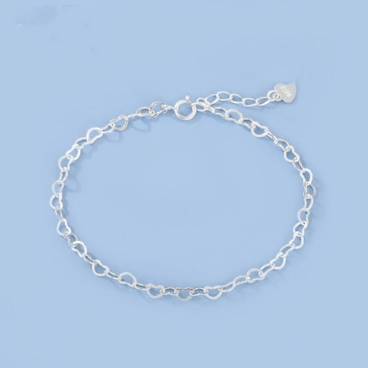 Silver chain bracelet on a light blue background
