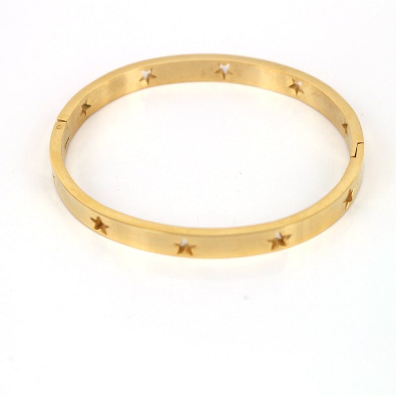 Gold bracelet with star designs on a white background