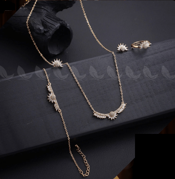 Jewelry set including a necklace, earrings, and ring on a dark surface