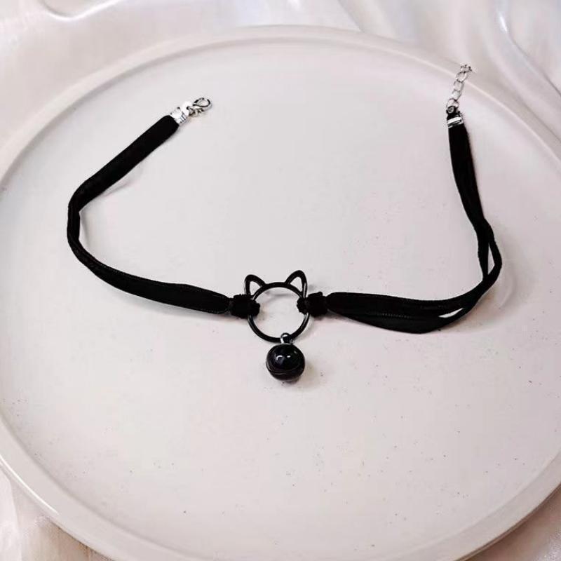 Black choker necklace with cat ear charm on a white plate