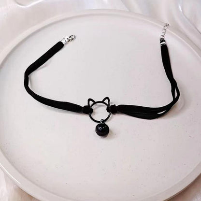 Black choker necklace with cat ear charm on a white plate