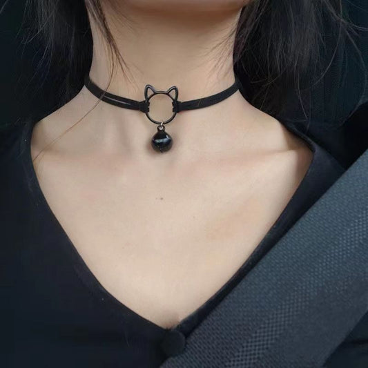 Black choker necklace with a cat design and black pendant on a person wearing a black top.