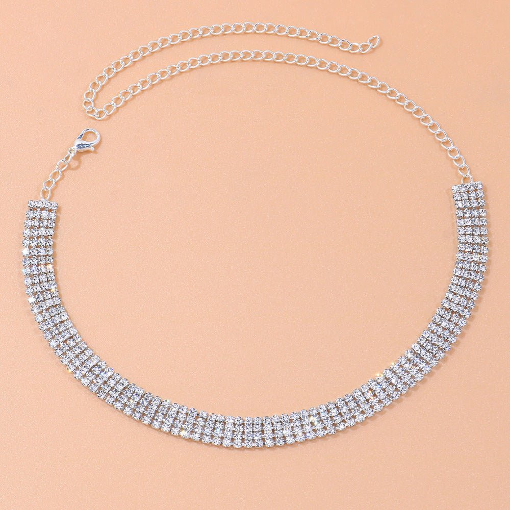 Silver necklace with clear stones on a beige background