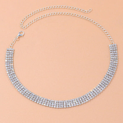 Silver necklace with clear stones on a beige background