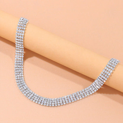Silver necklace with clear stones on a beige background